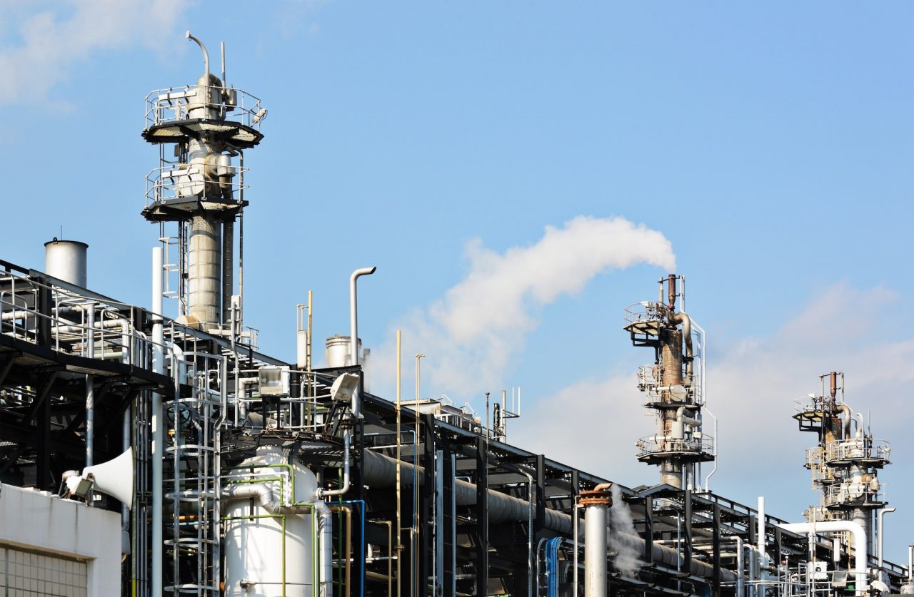 a factory with pipes and smoke coming out of it
